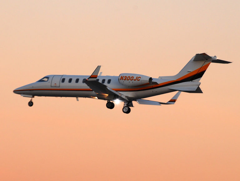 Bombardier Learjet 45 in flight through the orange sky.
