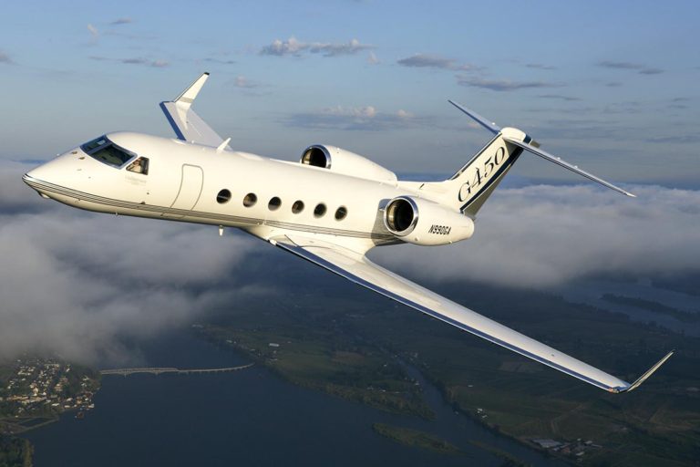 The Gulfstream G450 from Bloom Business Jets in flight through clouds over seas.